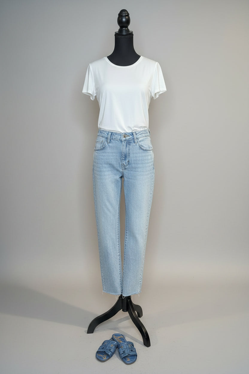 Mannequin wearing a white t-shirt and light blue jeans with shoes on the floor.