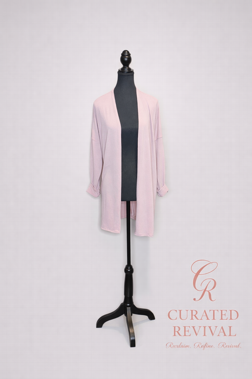 Mannequin wearing a light pink cardigan with 'Curated Revival' branding on a white background