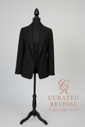 Black blazer on a mannequin with 'Curated Revival' branding on a beige background