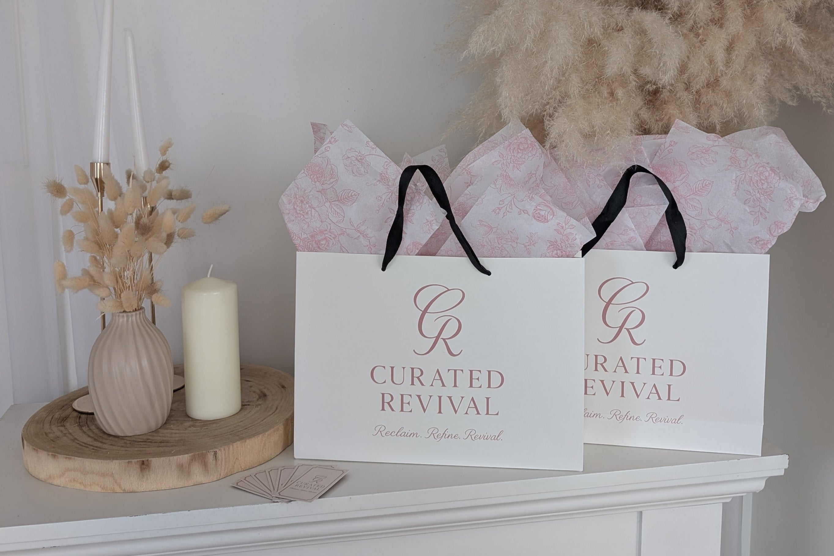Two 'Curated Revival' bags on a white surface with decorative elements.