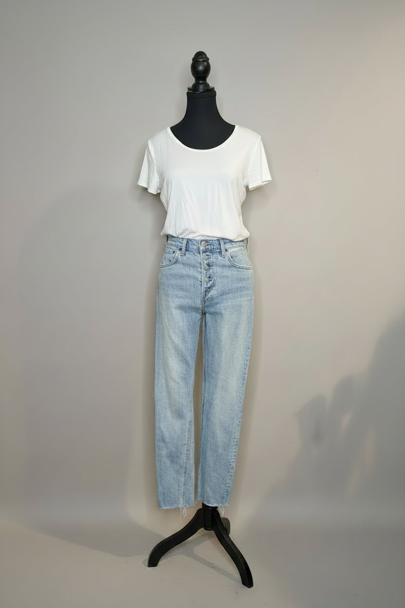 Mannequin wearing a white t-shirt and light blue jeans with shoes on a wooden floor.