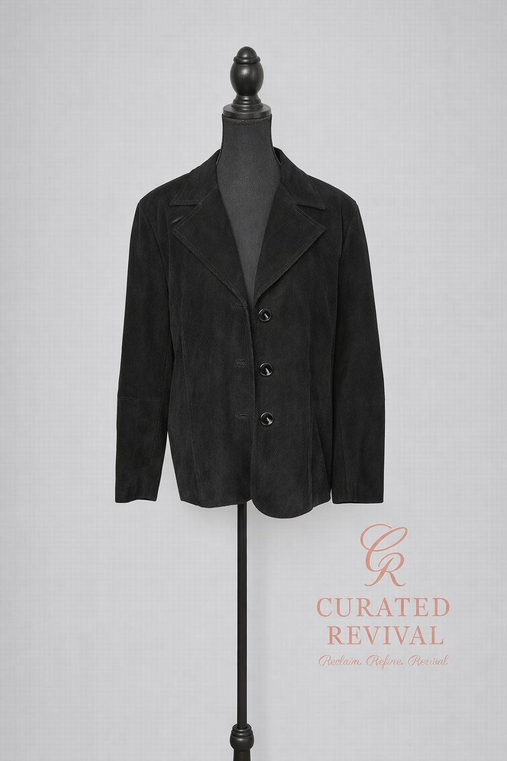 Black jacket on a mannequin with 'Curated Revival' logo in the corner.